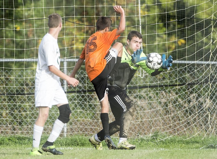 Mount View goalie Ricky Nelson (51) makes a save as Winslow's Isaac Burbank (15) looks for the rebound in Winslow on Wednesday.