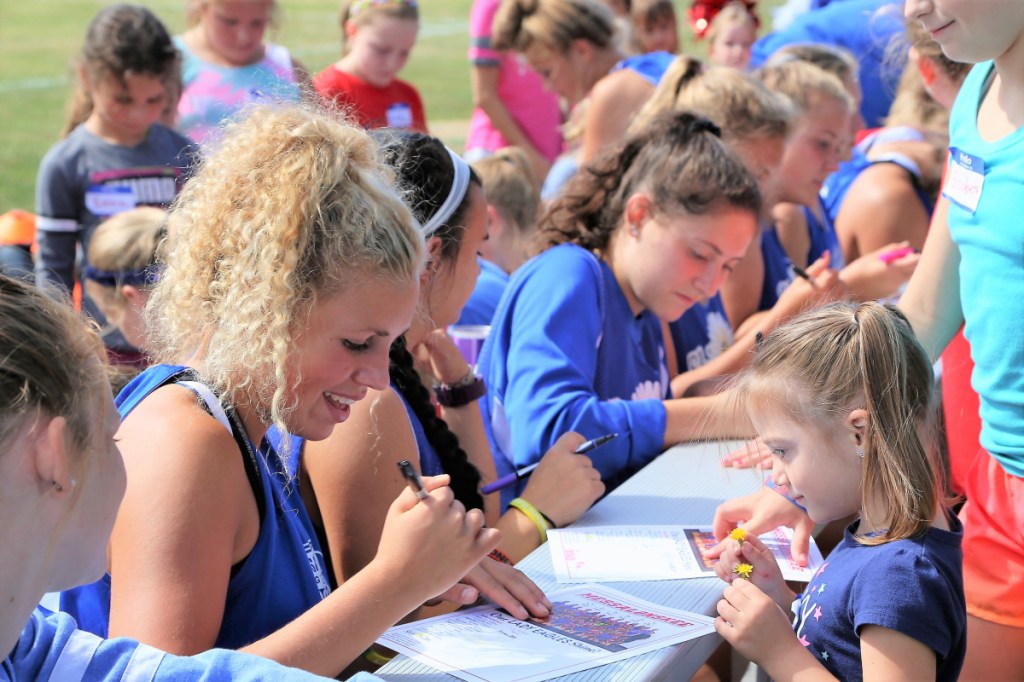 Kylie Wolfe, right, is all smiles as she gets an autograph from Alexa Brennan, left, and other members of the Messalonskee High School Girls Soccer team at the third annual "ShineOn Saturday" held Sept. 8 at Messalonskee High School. The event honored the late Cassidy Charette, of Oakland, who was a youth mentor and junior midfielder for the Eagles before her passing in 2014.