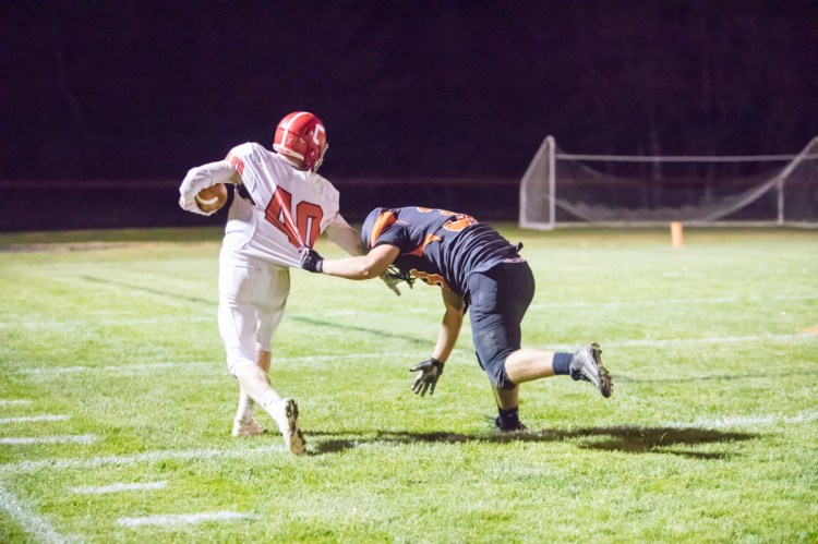 Cony's Matt Wozniak runs the ball into the end zone while Brunswick's Hunter Backhaus tries to take him down Friday night in Brunswick.