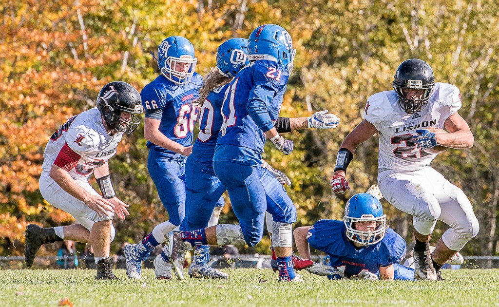 Lisbon's Isaiah Thompson, right, runs the balls down the field into Oak Hill's Hill's defense during Saturday afternoon's game in Wales.