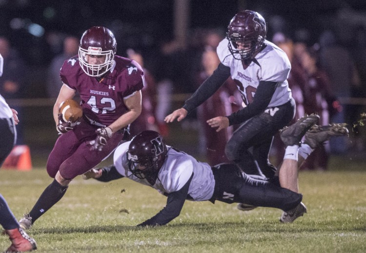 Staff photo by Michael G. Seamans 
 Maine Central Institute running back Tucker Sharples (42) breaks a tackle and hits a hole in the Nokomis defensive line during a Class C North game Friday night in Pittsfield.