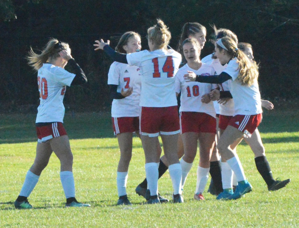 Messalonskee players gather around teammate Cloe Sisson (7) after Sisson scored the game's first goal against Brunswick in a Class A North semifinal game in Brunswick.