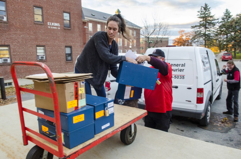 Department of the Secretary of State employees and courier service drivers take ballots out of vans and into the Elkins Building on Thursday in Augusta. The ranked choice voting counting is expected begin there at 9 a.m. Friday.