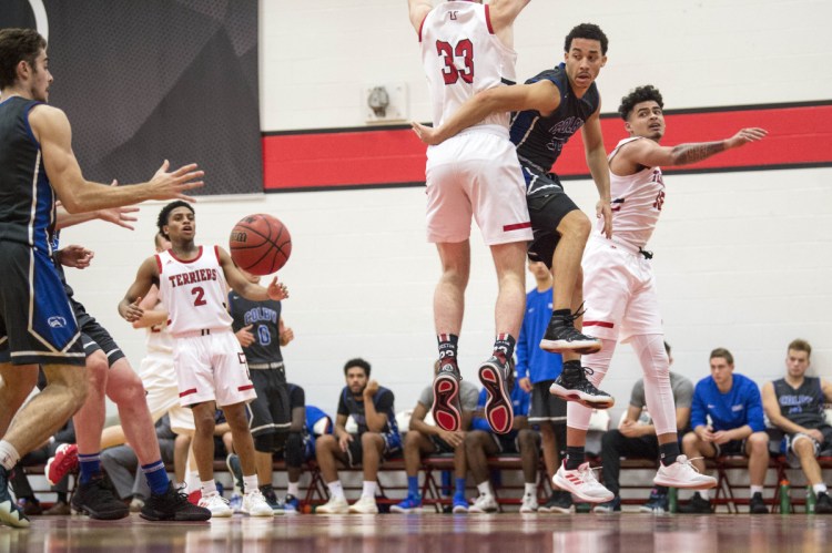 Colby College's Wallace Tucker (55) makes a pass to a teammate trailing on the fast break as Thomas College's Tyler Nixon (33) tries to defend at Thomas College in Waterville on Tuesday.