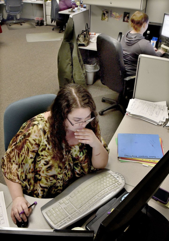 Brienna Pelletier, front, works on Thursday with other employees in the international audit department at the Parsifal Corp., which has moved its offices from Waterville to Eskelund Drive in Fairfield.