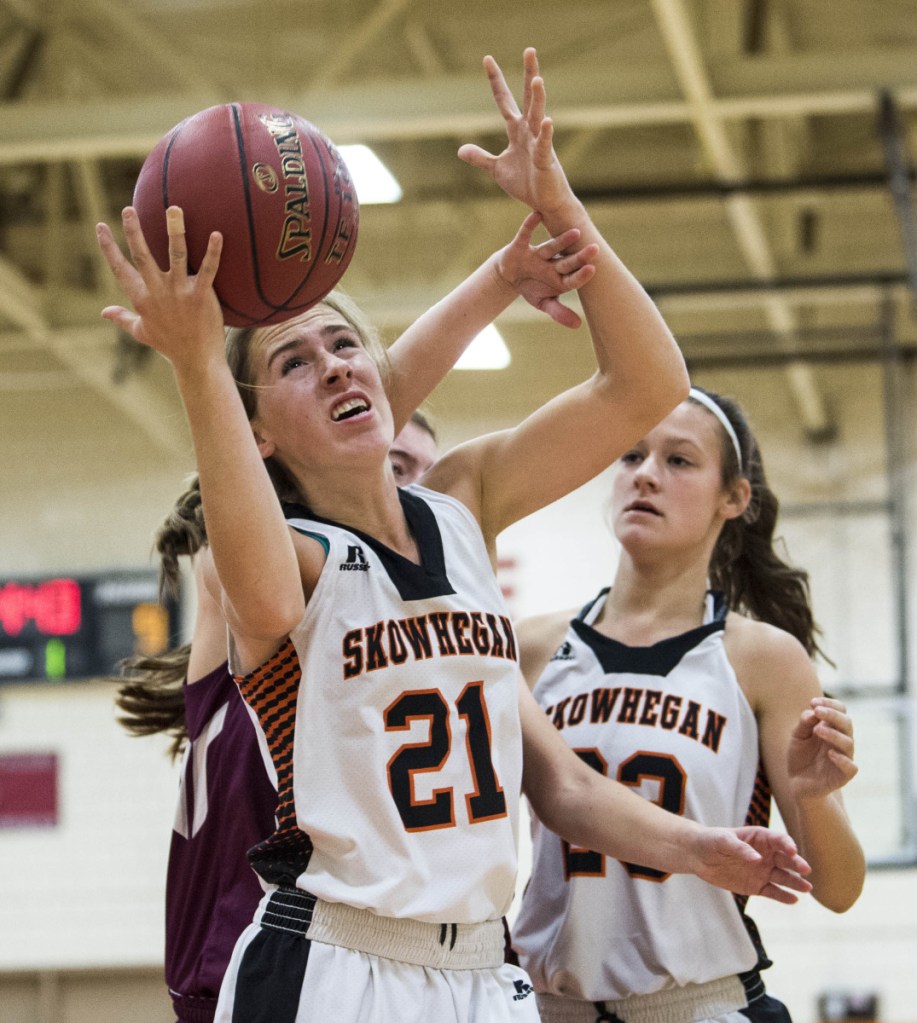 Skowhegan's Annie Cook (21) battles for a rebound during a preseason game against Monmouth last year.