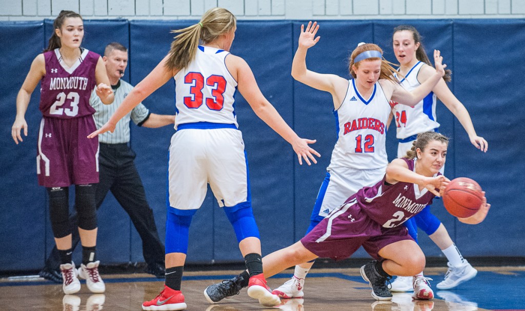 After being trapped by Oak Hill's Abby Nadeau, left and Sadie Waterman Monmouth's Abby Ferland passes off to a teammate during Saturday's girls basketball game between Oak Hill and Monmouth in Wales.