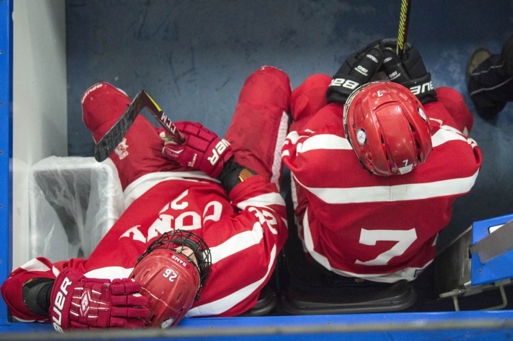 Cony's Joseph Arps (26) holds his head while he sits in the penalty box with teammate Elijah Bezanson as the final seconds tick off the clock in the first period Wednesday at Colby College in Waterville.