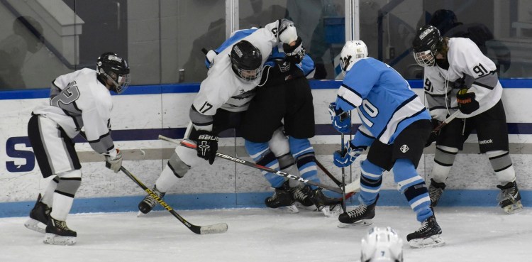 Kennebec's Cooper Hart (17) battles for the puck with an Orono/Old Town player during a Class B North game Tuesday in Waterville.