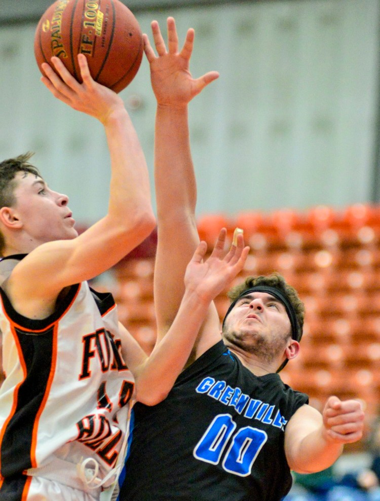 Forest Hills'  Parker Desjardins, left, gets fouled by Greenville defender Nicholas Calazzo during a Class D south semifinal game Wednesday at the Augusta Civic Center.