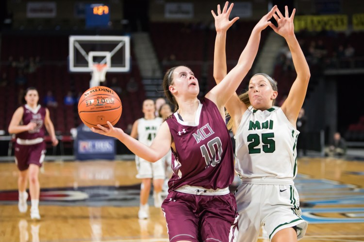 MCI's Sydney Farrar  (10) goes up for a shot as MDI's Georgia Candage defends  during a Class B North quarterfinal game Saturday in Bangor. 