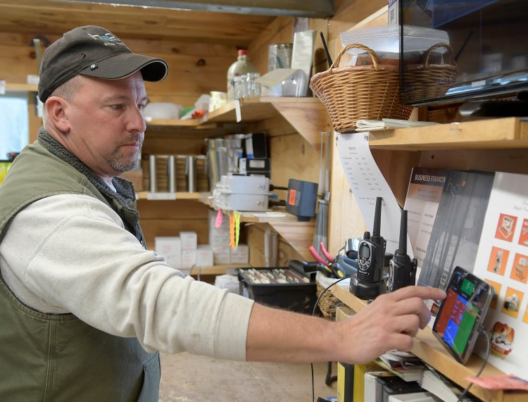 Kevin Bacon checks the flow of sap Sunday at his family's sugar bush at Bacon Farm Maple Products in Sidney. Radio monitors installed on sap lines send updates to electronic devices and his cell phone.