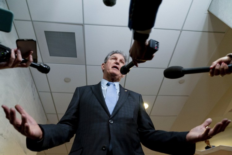 Sen. Joe Manchin, D-W.Va., a key holdout vote on President Biden's domestic agenda, speaks to reporters on Capitol Hill on Wednesday. 