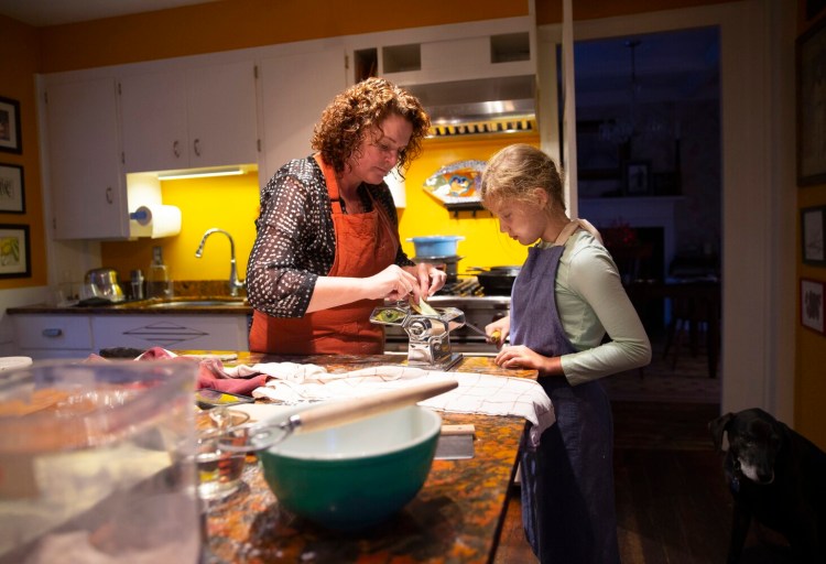 BRUNSWICK, ME - DECEMBER 8: Green Plate Special. Maddie Brown, 11 of Brunswick, a fifth-grader at NYA, helps Christine Burns Rudalevige make spinach and plain egg pasta dough using a hand crank pasta machine. (Photo by Derek Davis/Staff Photographer)