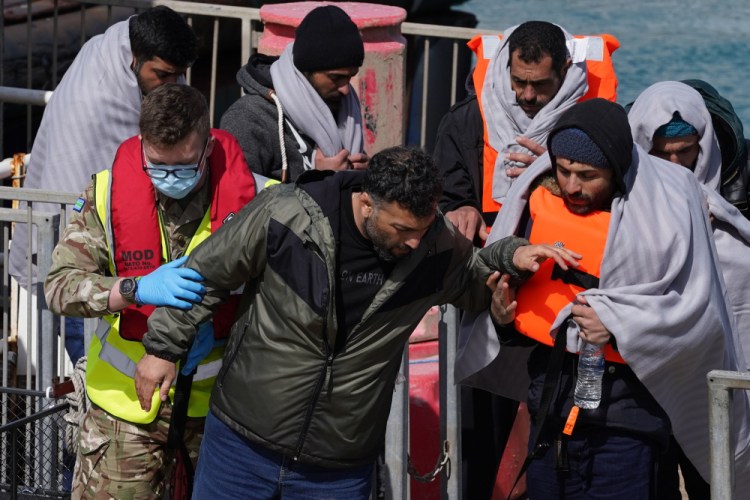 A group of people thought to be migrants are brought in to Dover, Kent, by the RNLI, following a small boat incident in the English Channel, Thursday. 