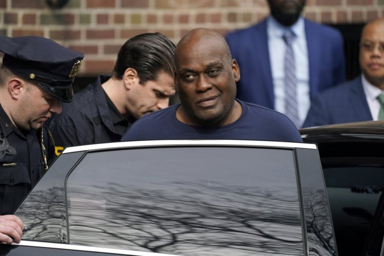 Law enforcement officials lead subway shooting suspect Frank R. James, 62, center right, away from a police station and into a vehicle in New York on Wednesday. 