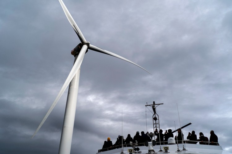 FILE - Guests tour one of the turbines of America's first offshore wind farm, owned by the Danish company, Orsted, off the coast of Block Island, R.I., as part of a wind power conference, Oct. 17, 2022. The offshore wind power energy has ambitious plans for generating electricity for millions of American homes. But it faces opposition from local residents in many places that could significantly slow down a national goal to power 10 million homes with wind energy by 2030. (AP Photo/David Goldman, File)